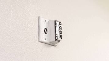 A wall-mounted intercom system with a keypad.