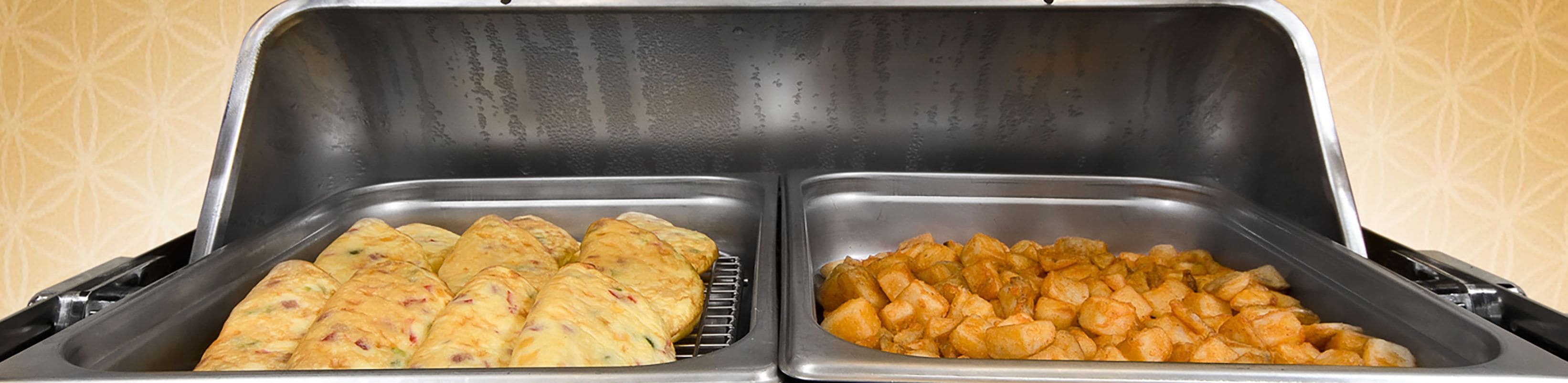 Buffet amb dues safates de menjar, una amb pastissos i l'altra amb trossos.