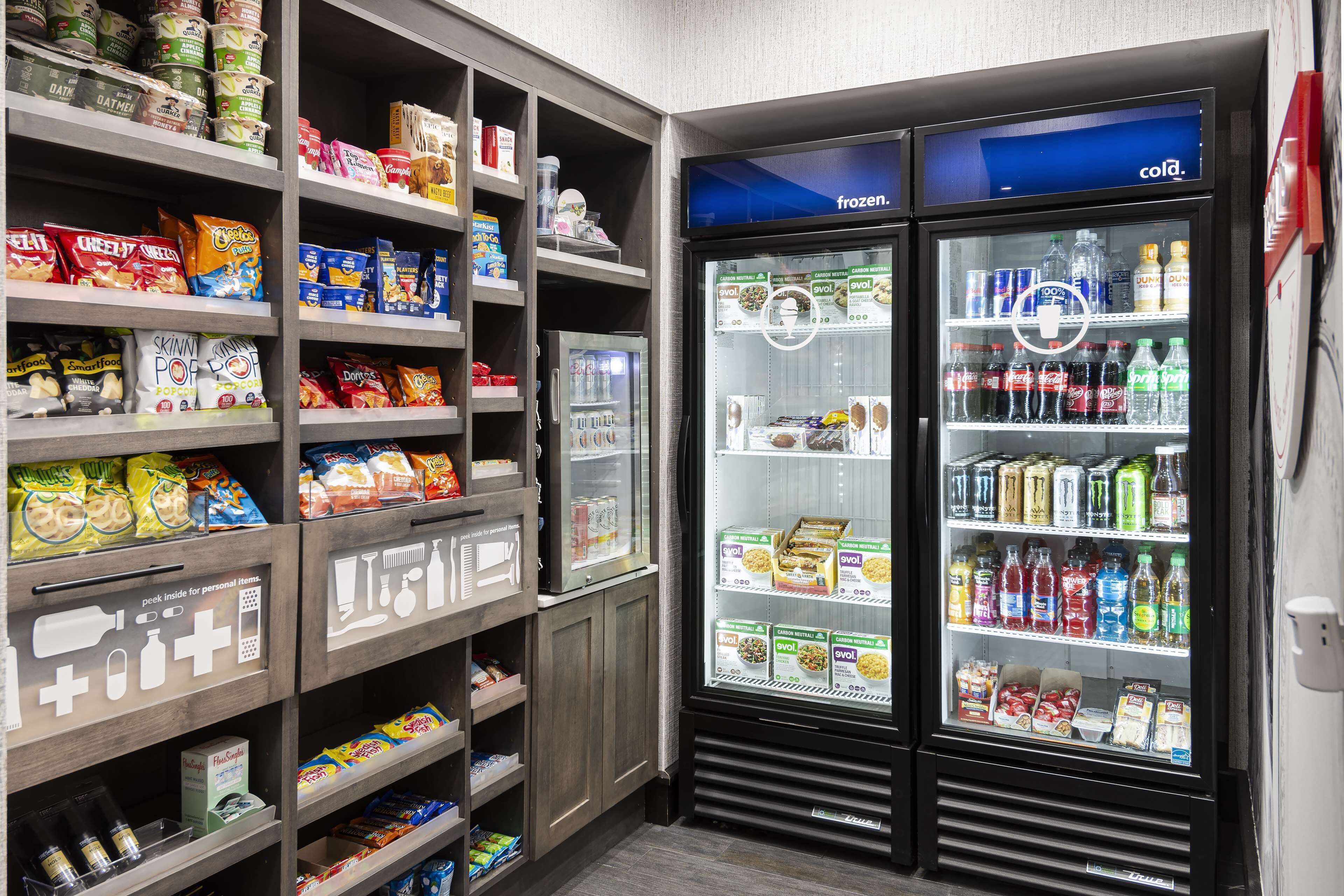 A self-service snack and beverage kiosk with various snacks, drinks, and frozen items.