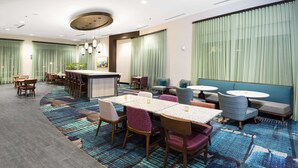 A hotel lobby with a bar area, seating arrangements, and a patterned carpet. - Hampton Inn & Suites Raleigh Downtown (Raleigh)