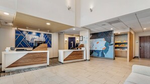 A hotel reception area with two reception desks, a large wall map, and a wooden reception desk.