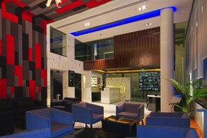 Una hall moderna con reception, area salotto e un'ampia finestra.