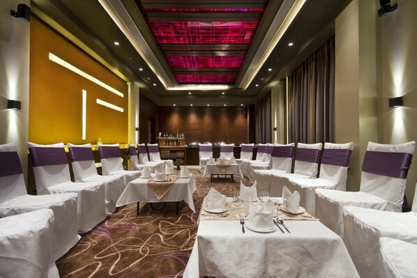 A banquet hall with white tables and purple sashes, equipped with glassware and cutlery. - The Fern Residency Chandigarh (Chandigarh)