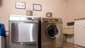 A laundry room with a front-loading washer and dryer, a blue appliance, and a white cabinet. - Aparthotel Adagio Lyon Patio Confluence (Lyon)