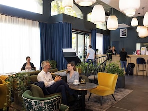 A modern hotel lobby with a seating area, a reception desk, and large windows. - Aparthotel Adagio Lyon Patio Confluence (Lyon)