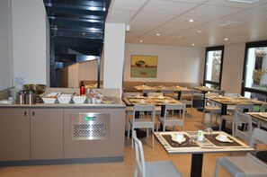 Et moderne spiseområde med buffet, siddepladser og udsigt til det fri.