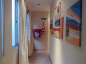 Stylish hallway with artworks and a clear exit sign.