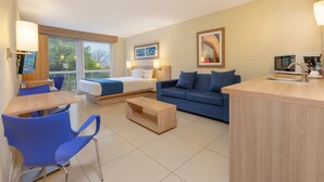 A modern hotel room with a bed, a sofa, a dining area, and a kitchen counter. - City Express by Marriott San Jose Costa Rica (Ulloa)
