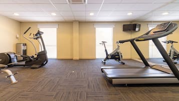 A gym with treadmills, elliptical machines, and a stationary bike.