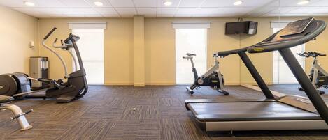 Una palestra con tapis roulant, ellittiche e cyclette.