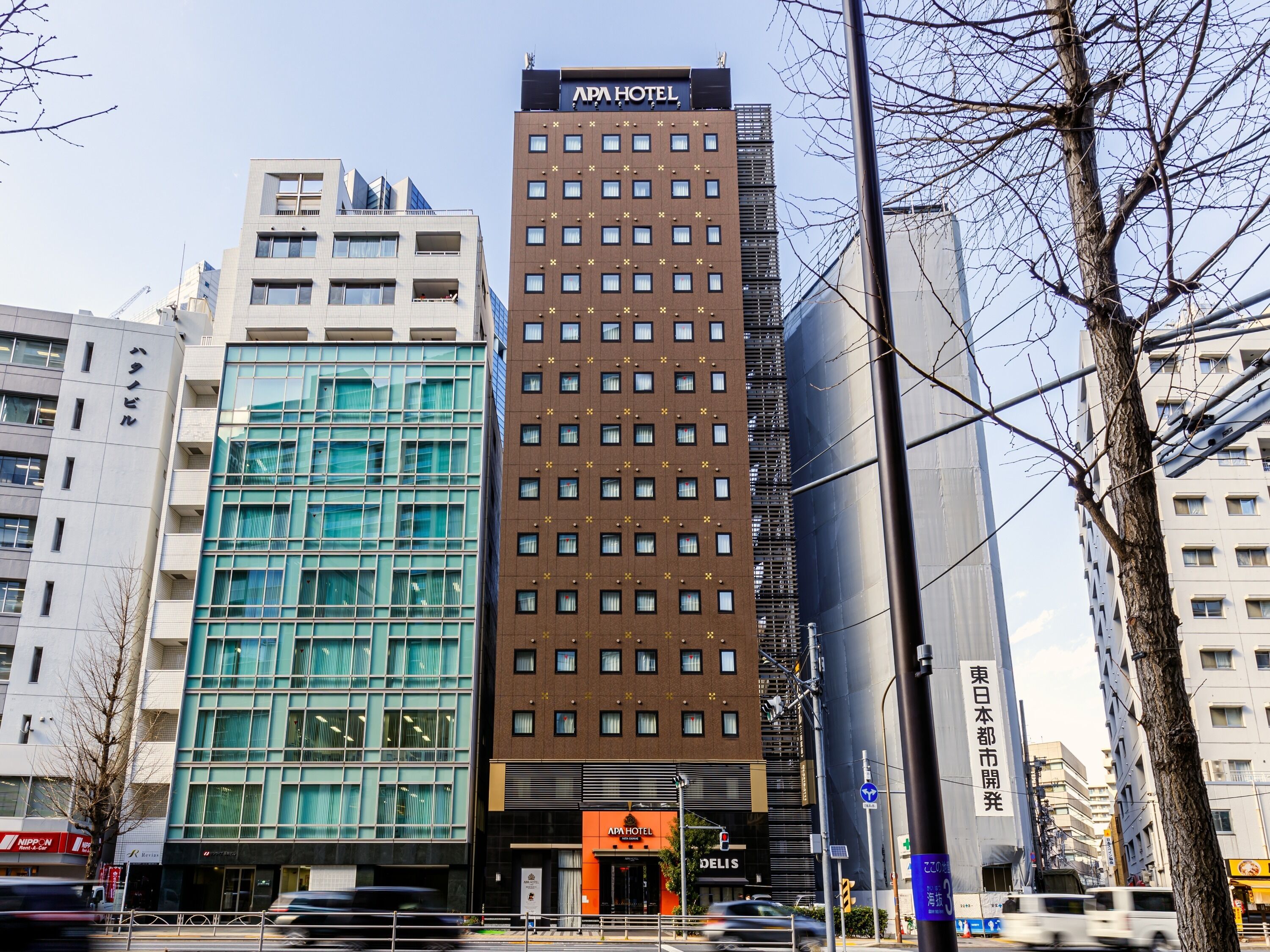 En modern hotellbyggnad med en tydlig skylt som visar att det är ett APA HOTEL.