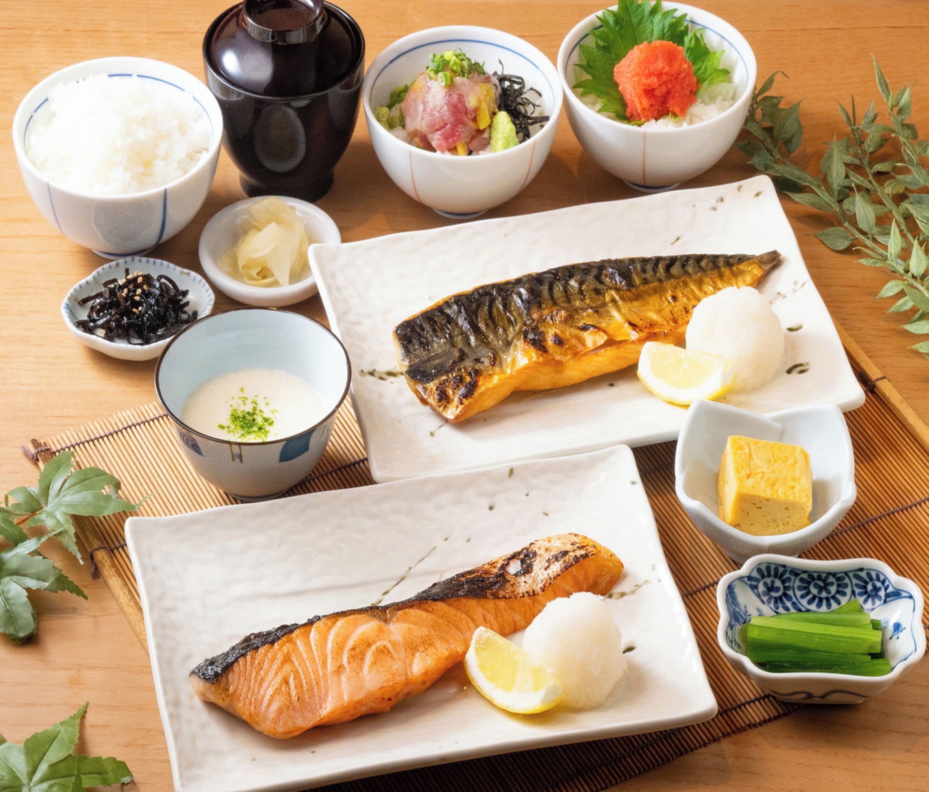 Variedad de platos japoneses, como sushi, sashimi y cuencos de arroz.