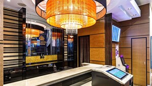 A modern hotel reception area with a marble counter, a digital kiosk, and a large chandelier. - APA Hotel Mita Ekimae (Tokyo)