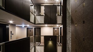 A modern elevator area with multiple doors, a control panel, and a glass partition. - APA Hotel Mita Ekimae (Tokyo)