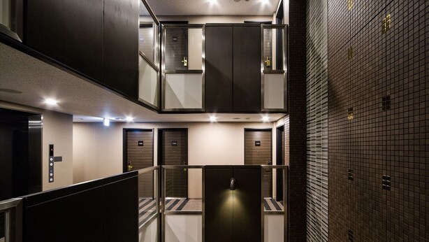 A modern elevator area with multiple doors, a control panel, and a glass partition. - APA Hotel Mita Ekimae (Tokyo)