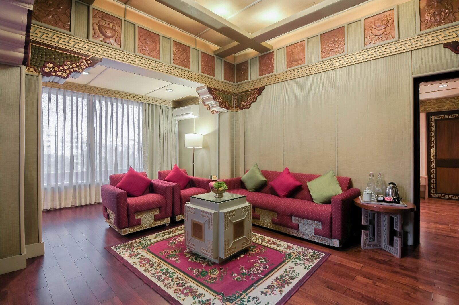 A room with a sofa set, a coffee table, and a small side table with a lamp.
