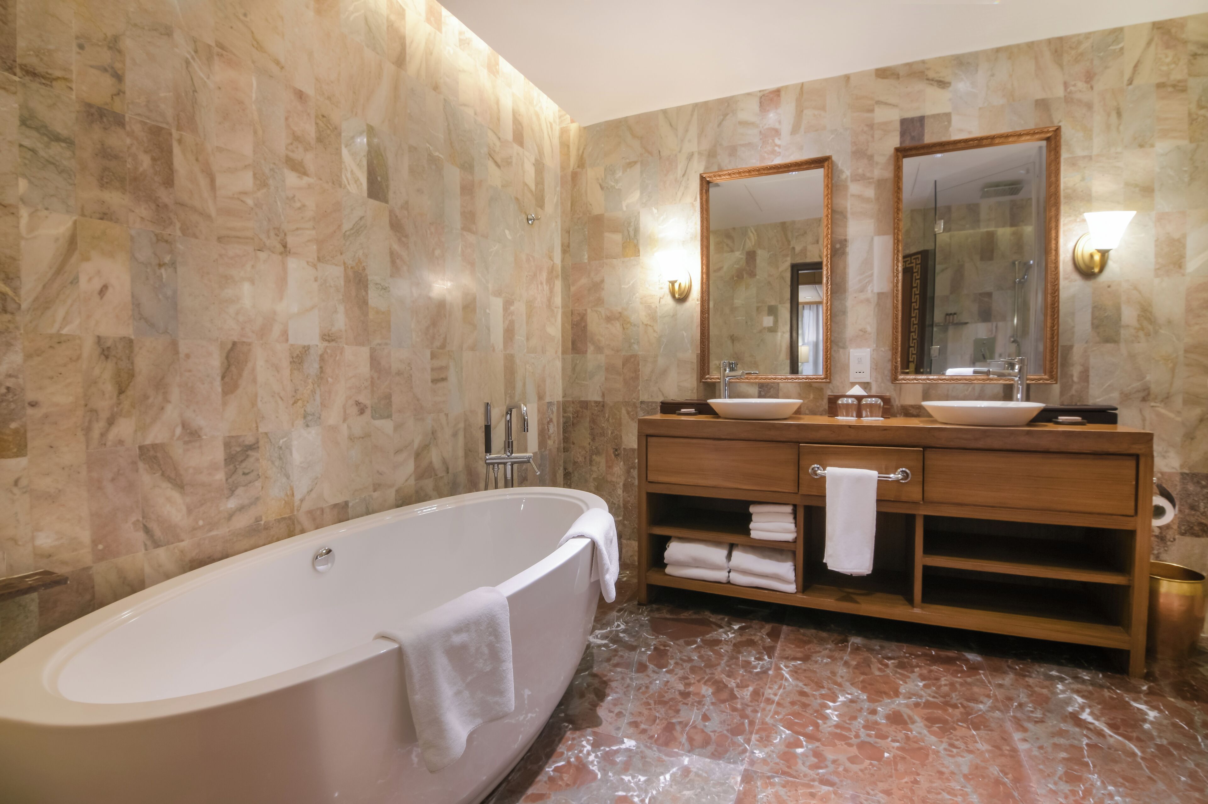 A bathroom with a freestanding bathtub, two sinks, and a vanity with a mirror.