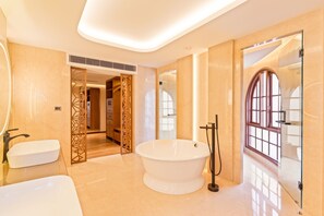 A modern bathroom with a freestanding bathtub, a vanity with a sink, and a glass shower enclosure. - Hotel Yak & Yeti (Kathmandu)