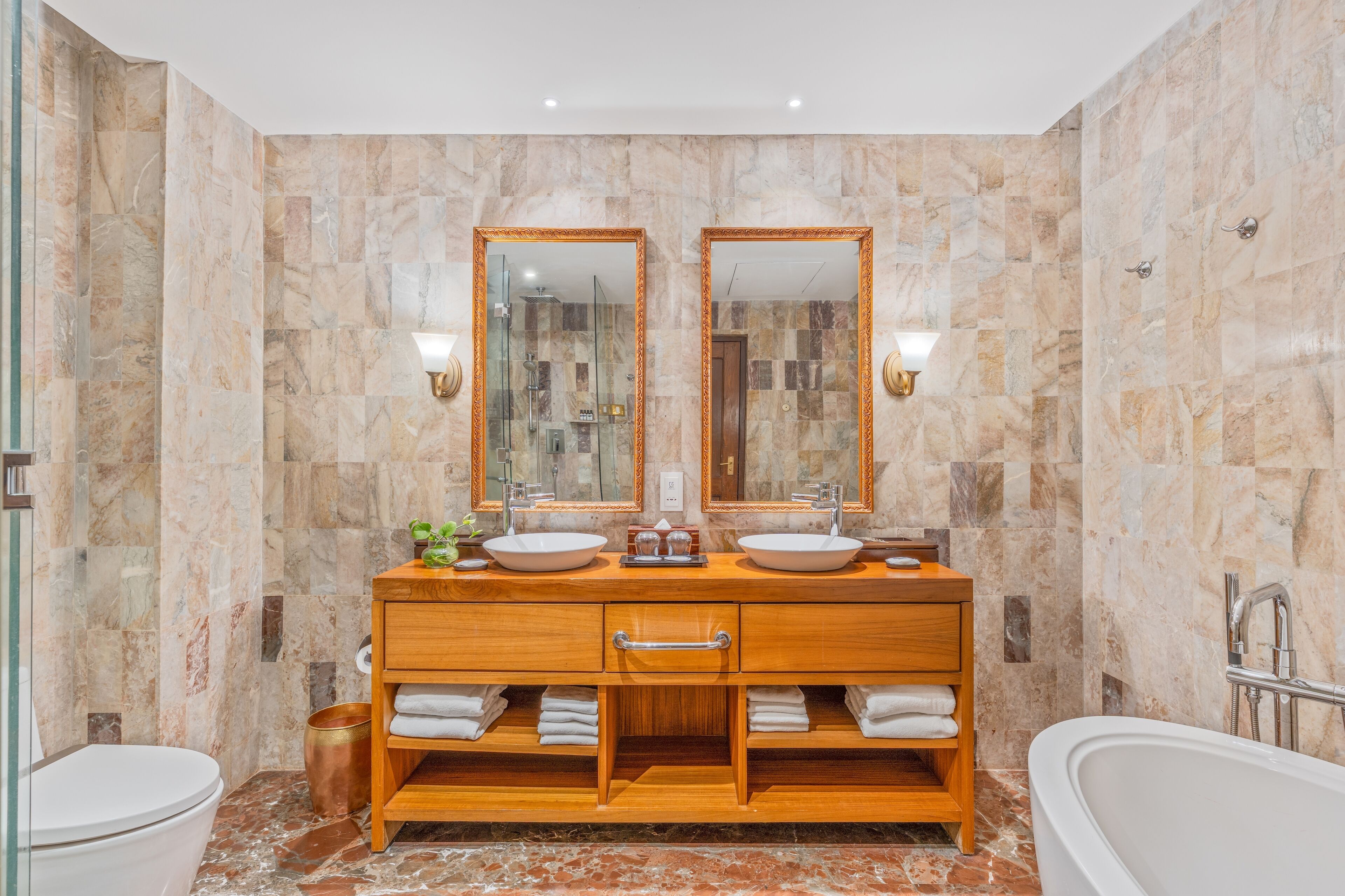 Een badkamer met twee wastafels, een wastafelmeubel, een bad en een douche.