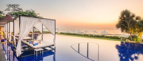 Una piscina al aire libre, camas de piscina gratis, sombrillas