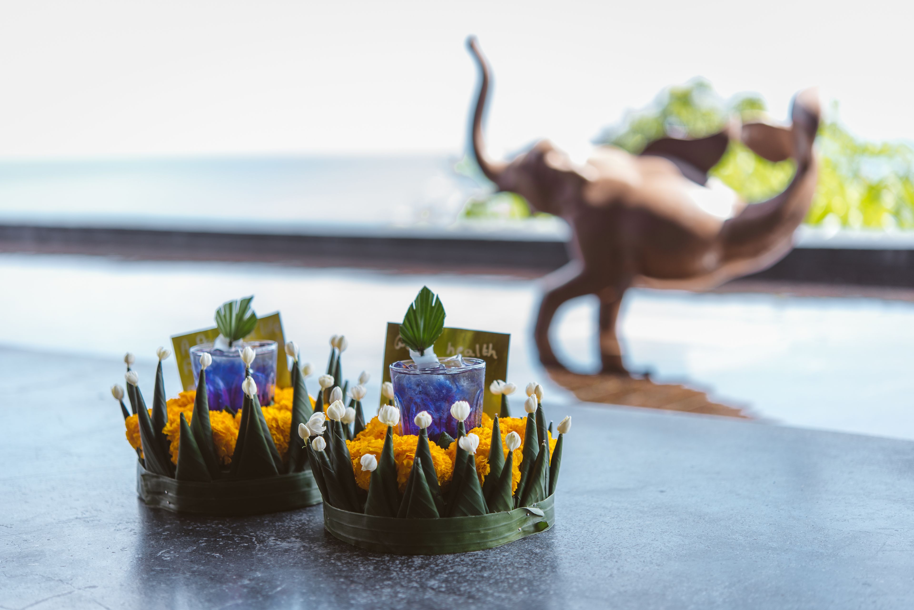 Zwei Glasbehälter mit Studentenblumen und einem dekorativen Gegenstand auf einem Tisch.