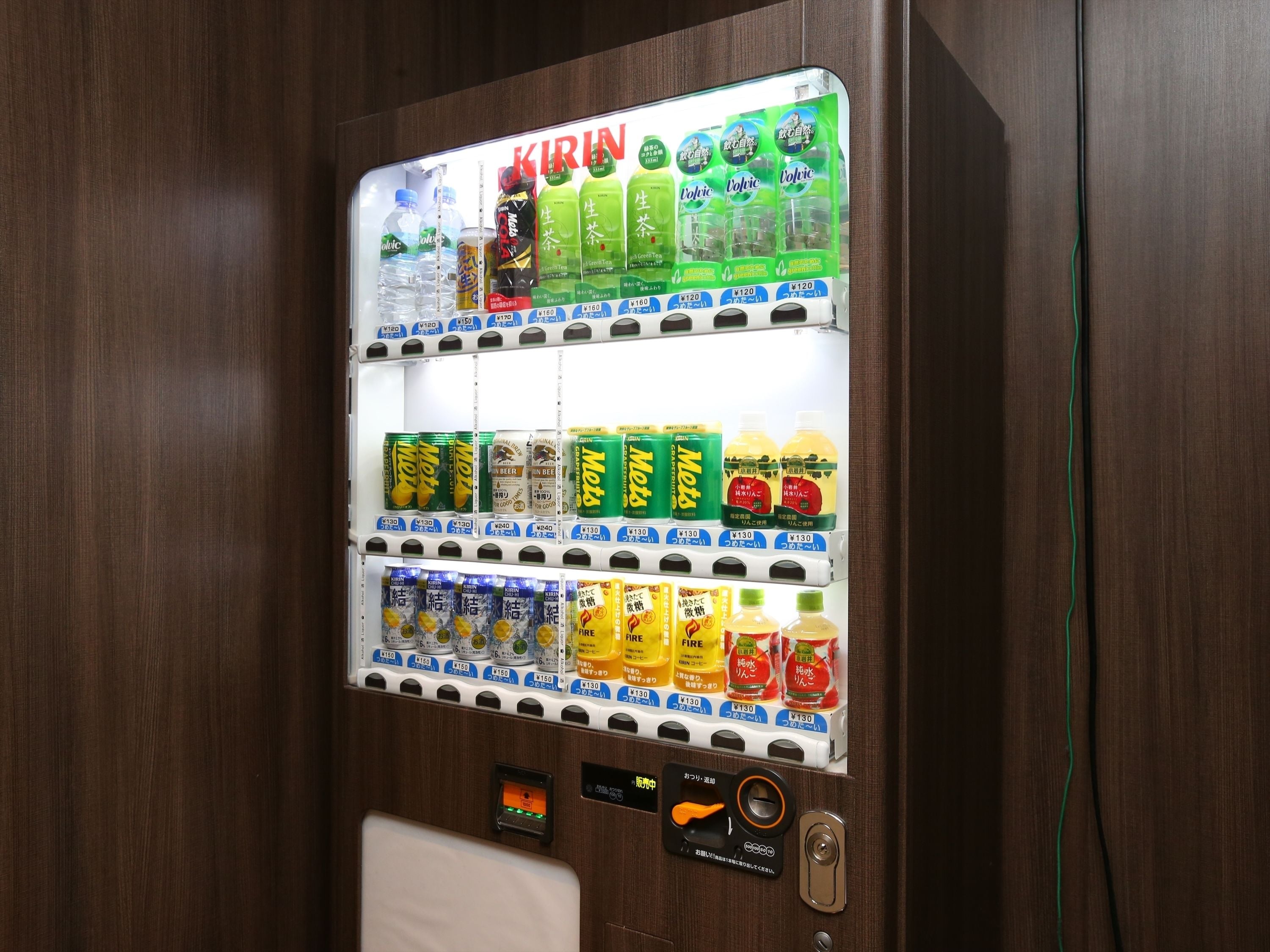 Un distributeur automatique proposant une variété de boissons et d’en-cas, notamment des marques comme Kirin, Motoh et Fire.