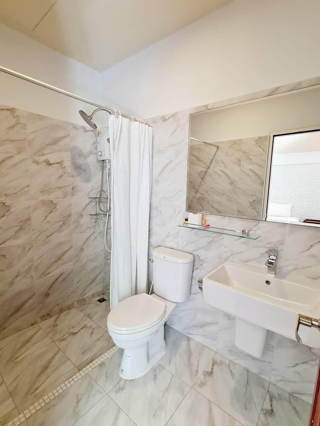 A bathroom with a shower, toilet, and sink.