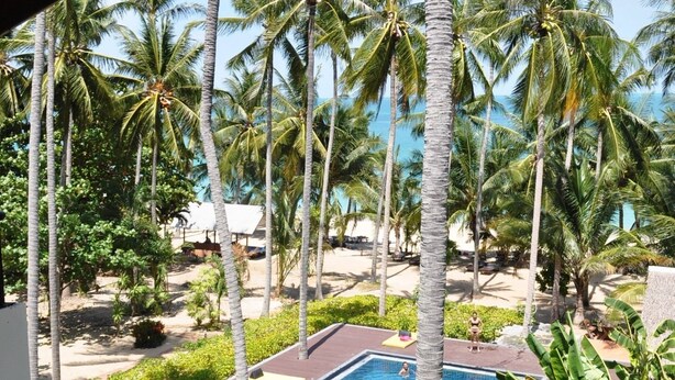 A pool area with palm trees and a view of the beach. - ASTROCOCO beach resort by Coconut Beach (Koh Samui)
