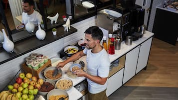 A kitchen with a variety of food items, a coffee machine, and a microwave.