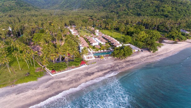 An aerial view of a resort with multiple bungalow-style buildings, a beach, and a pool area. - Living Asia Resort & Spa (Senggigi)