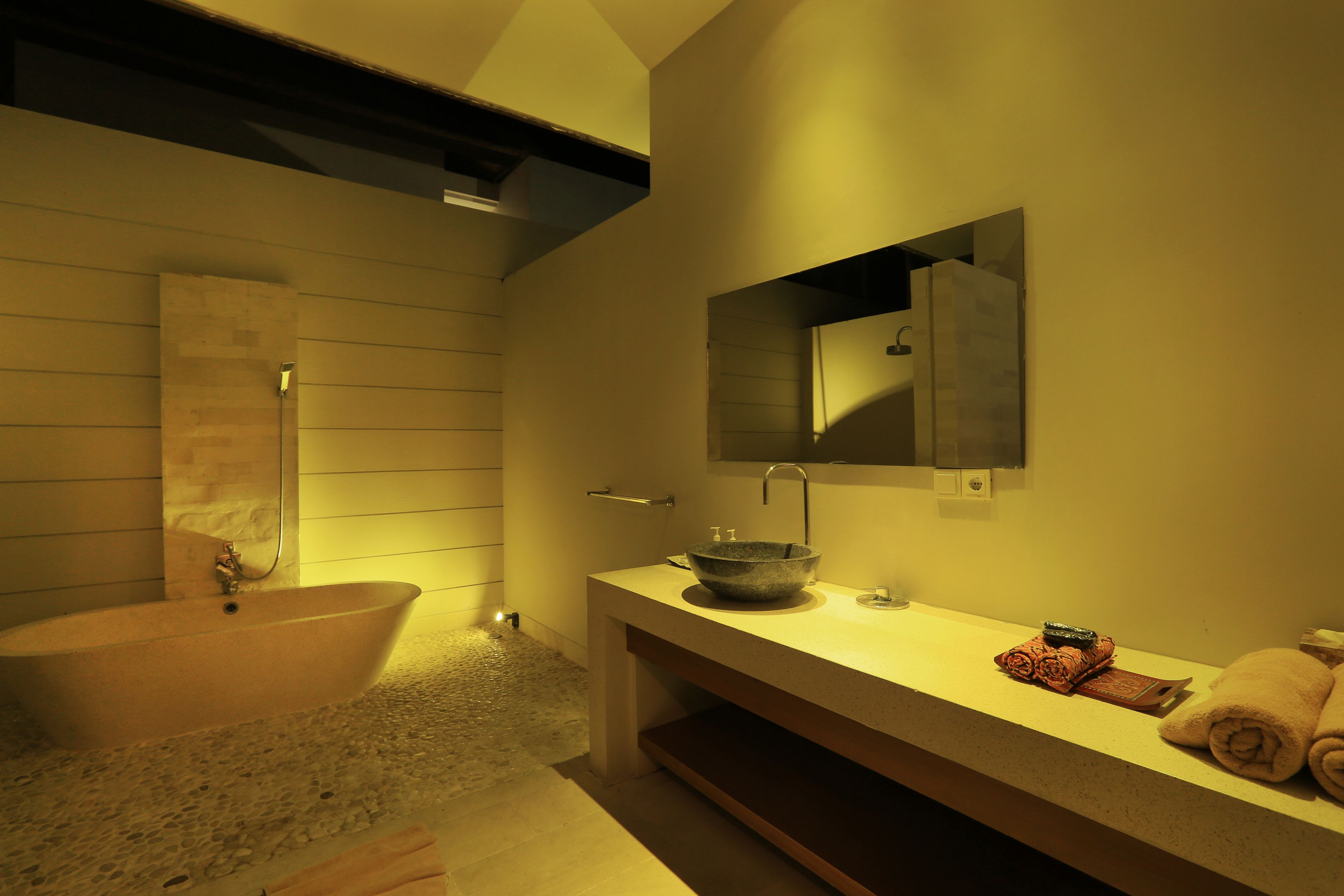 A modern bathroom with a freestanding bathtub, a large mirror, and a countertop with a bowl sink.