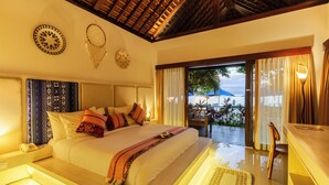 A spacious bedroom with a large bed, a wooden ceiling, and a view of the outdoors. - Living Asia Resort & Spa (Senggigi)