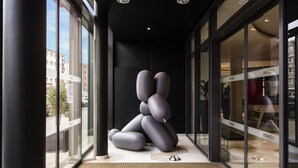A modern interior with a unique sculptural installation, large glass windows, and a visible store named 'adagio'. - Aparthotel Adagio Köln City (Cologne)