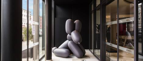 En modern inredning med en unik skulptural installation, stora glasfönster och en butik med namnet ”adagio” som är väl synlig.