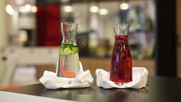 Two glass bottles with different colored liquids on a table, each with a white napkin.