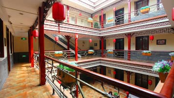 A multi-level atrium with traditional architectural elements, including red lanterns and potted plants.