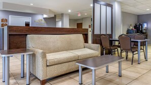 A hotel lobby with a reception desk, a sofa, and a dining area with chairs and tables. - Microtel Inn & Suites By Wyndham Sylva Dillsboro Area (Sylva)