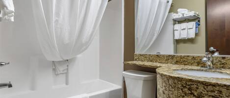 Un baño con bañera, inodoro y lavamanos.