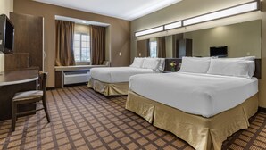A hotel room with two beds, a desk, a chair, a TV, and a window with curtains. - Microtel Inn & Suites By Wyndham Sylva Dillsboro Area (Sylva)