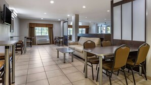A hotel room with a dining area, a sofa, and a TV. - Microtel Inn & Suites By Wyndham Sylva Dillsboro Area (Sylva)