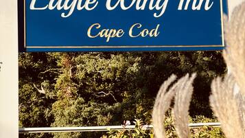 A sign for Eagle Wing Inn in Cape Cod with a sailboat logo.