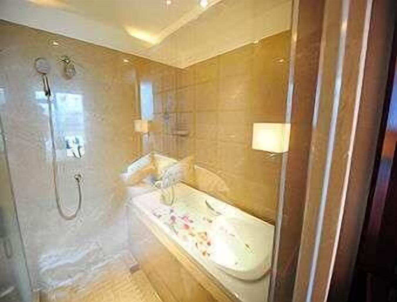 A bathroom with a bathtub, shower, and a mirror.