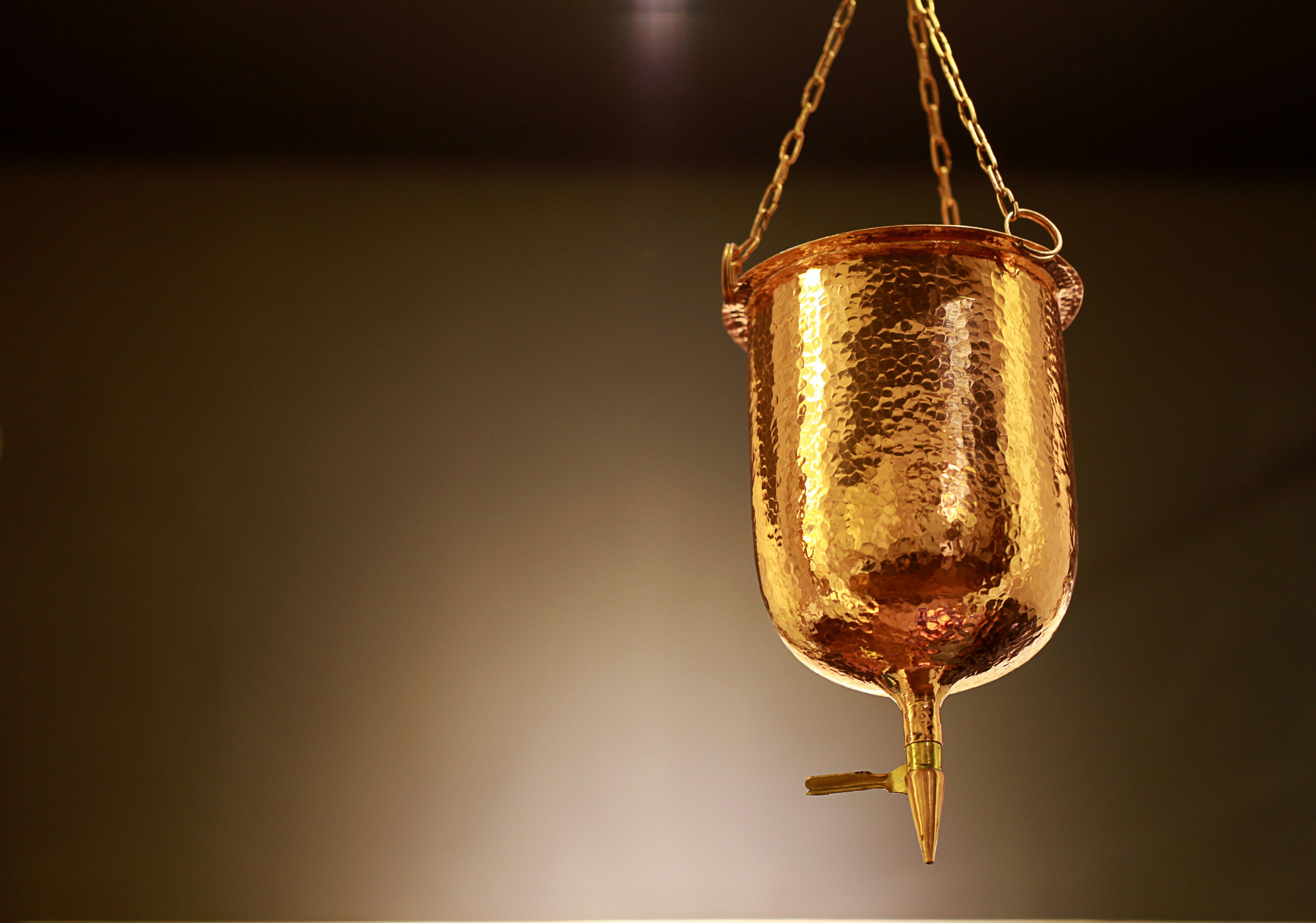 A hanging golden object with a chain.