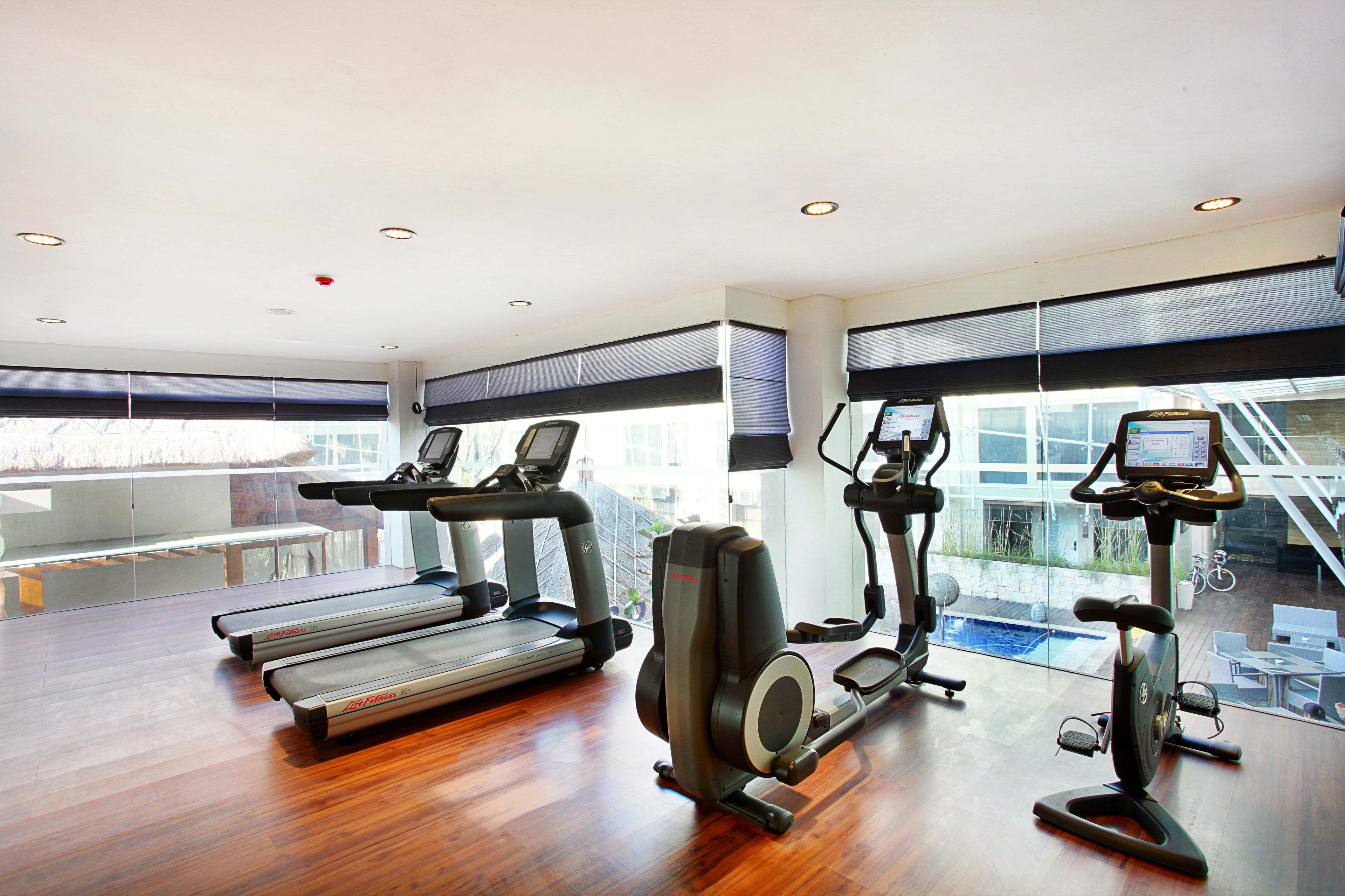 A gym with treadmills, elliptical machines, and a stationary bike.