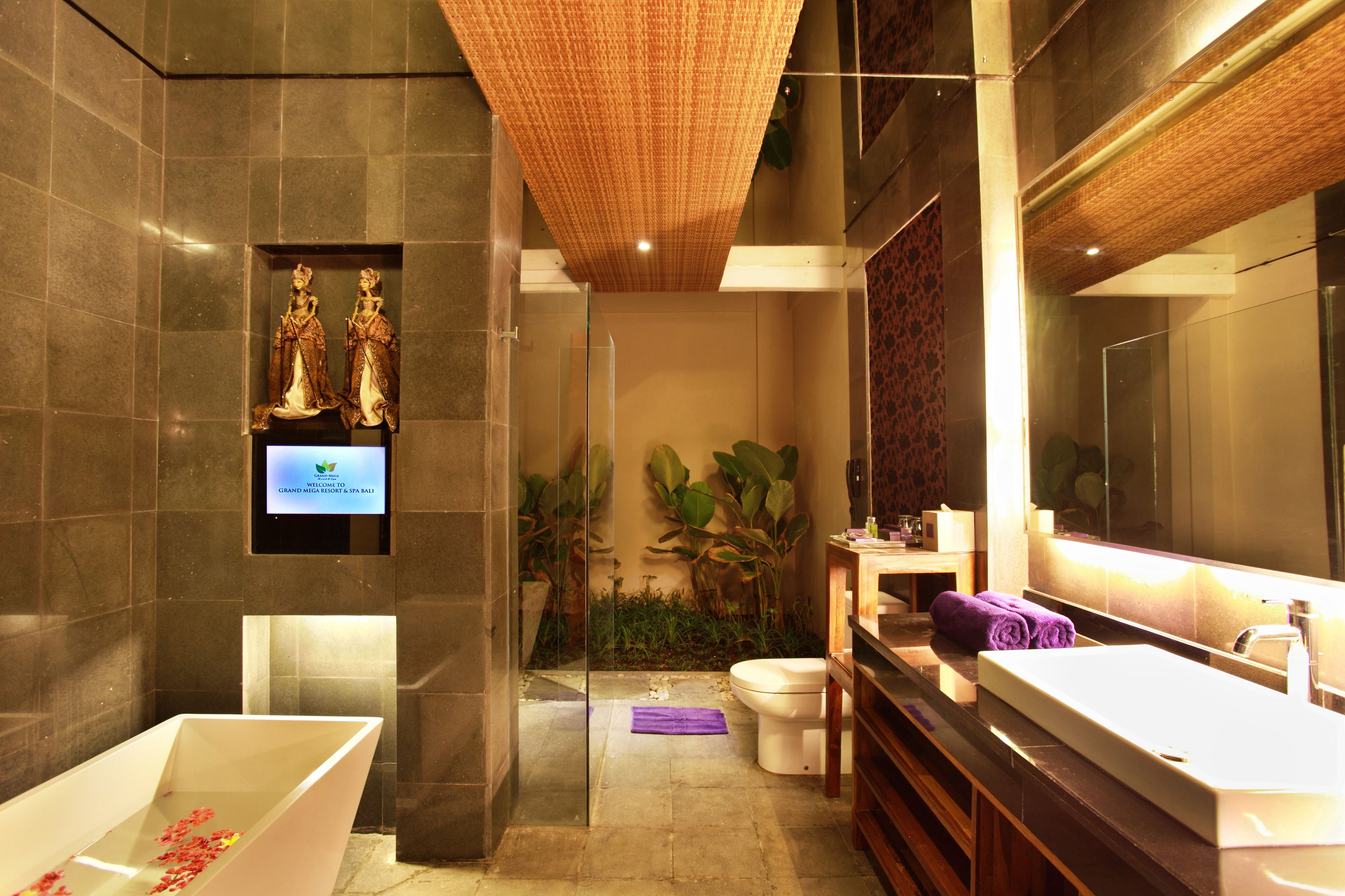 Une salle de bain moderne avec une grande baignoire, des toilettes et un meuble-lavabo avec un miroir.