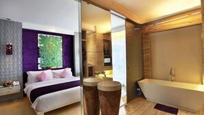 A modern hotel room with a bed, a large mirror, a bathtub, and a bathroom vanity. - Grand Mega Resort & Spa Bali (Kuta)
