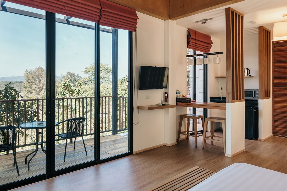 Una habitación moderna con balcón, comedor y cocina.