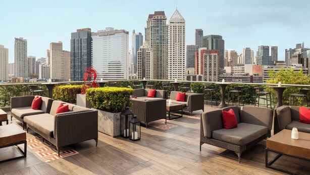 A rooftop lounge with outdoor seating, city skyline views, and modern furnishings. - Raffles Makati (Makati)