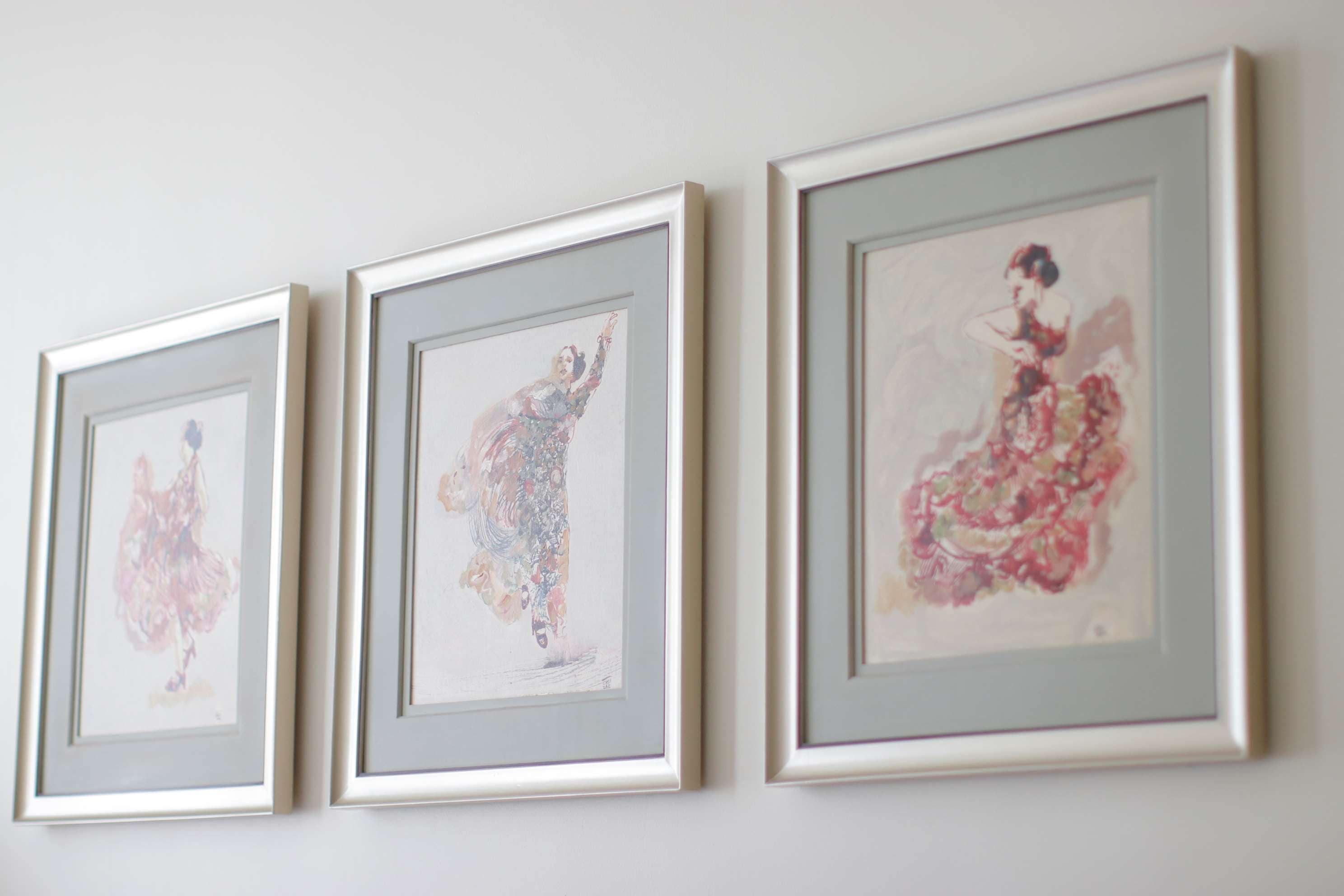 Three framed artworks on a wall.