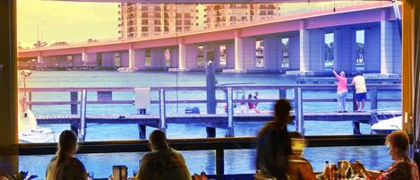 A restaurant with a view of a waterfront and a bridge.